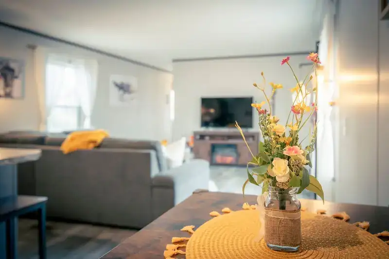 Comfy Lodge House: Dining table with living room and TV beyond