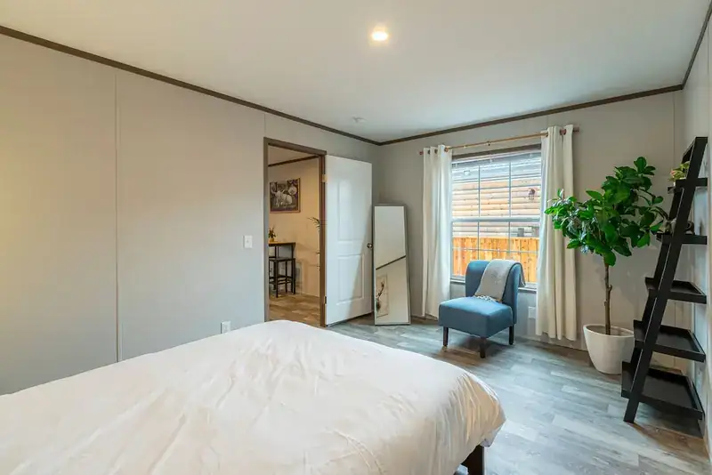 Comfy Lodge House: Bedroom with bed and armchair by window