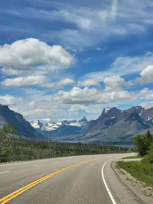 Road curving toward mountains in Glacier