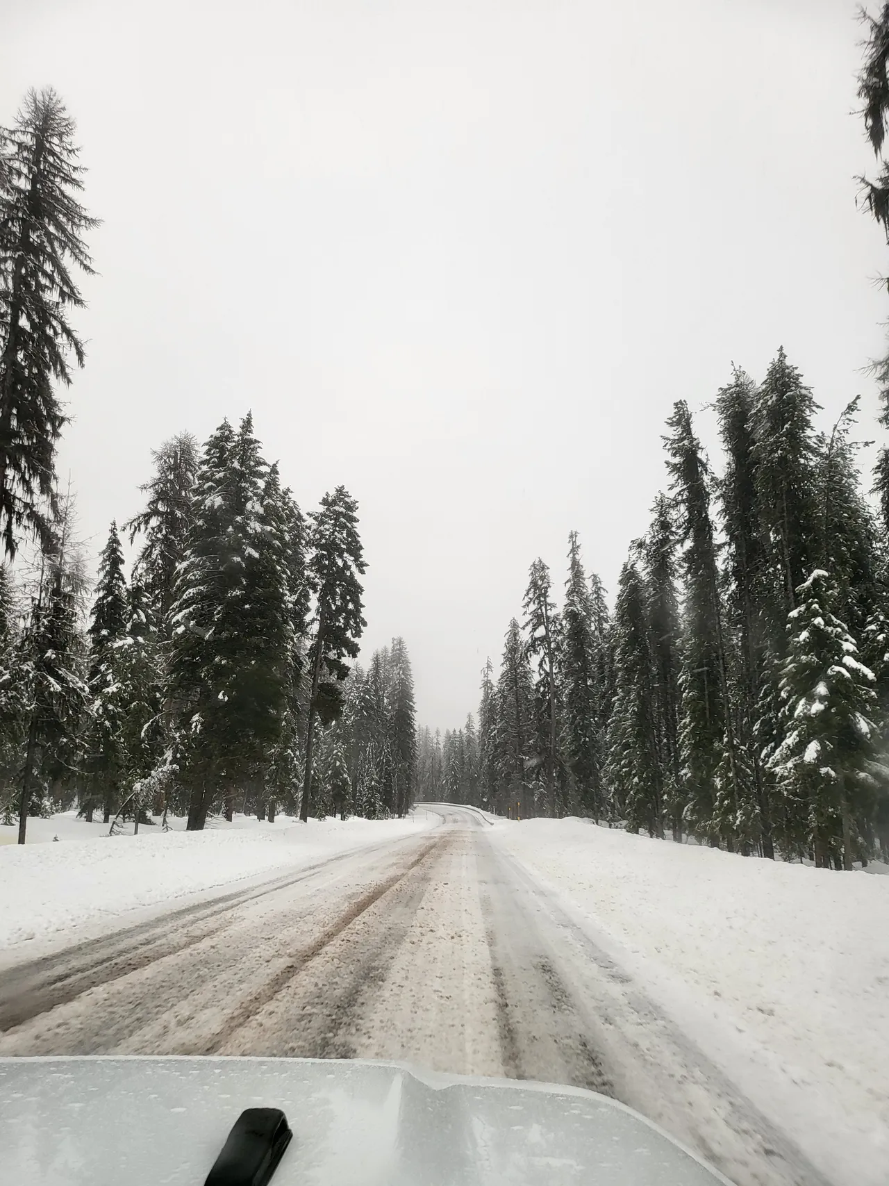 Snow-covered forest road in winter near Big Sky, Montana