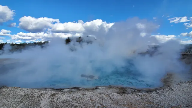 Steaming blue hot spring under a cloudy sky in Yellowstone